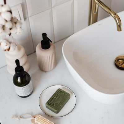 A modern bathroom sink with various cosmetic products, highlighting self-care essentials.